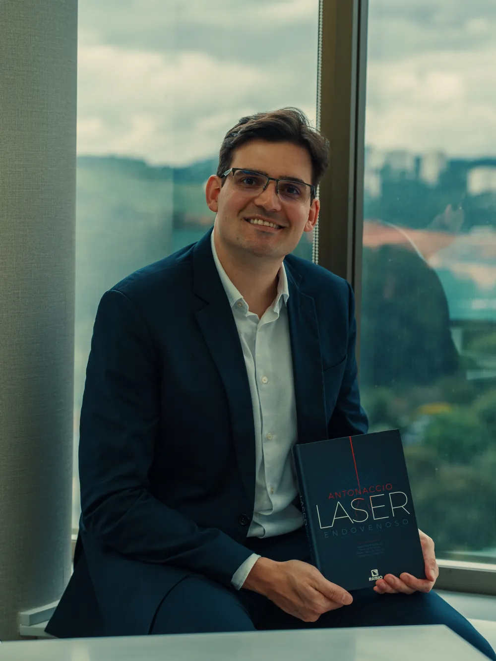 Dr. Alexandre Antonaccio segurando o livro Laser Endovenoso